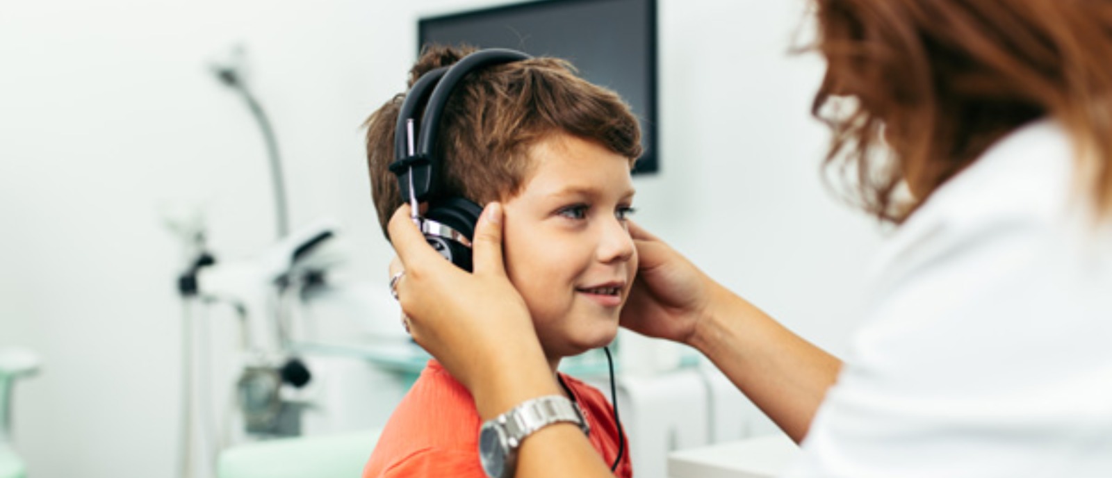 Follow-up visits for hearing aid adjustments and support for children | Aanvii Hearing Child wearing hearing aids during a follow-up visit for adjustments and support